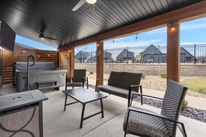 Eine Terrasse im Freien mit Grill, Sitzgelegenheit und Blick auf Wohnhäuser.