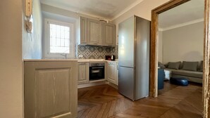 Una cocina moderna con armarios de madera, un refrigerador de acero inoxidable y un suelo con patrón de espiga.