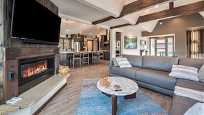 A modern living room with a fireplace, a grey sofa, and a coffee table.