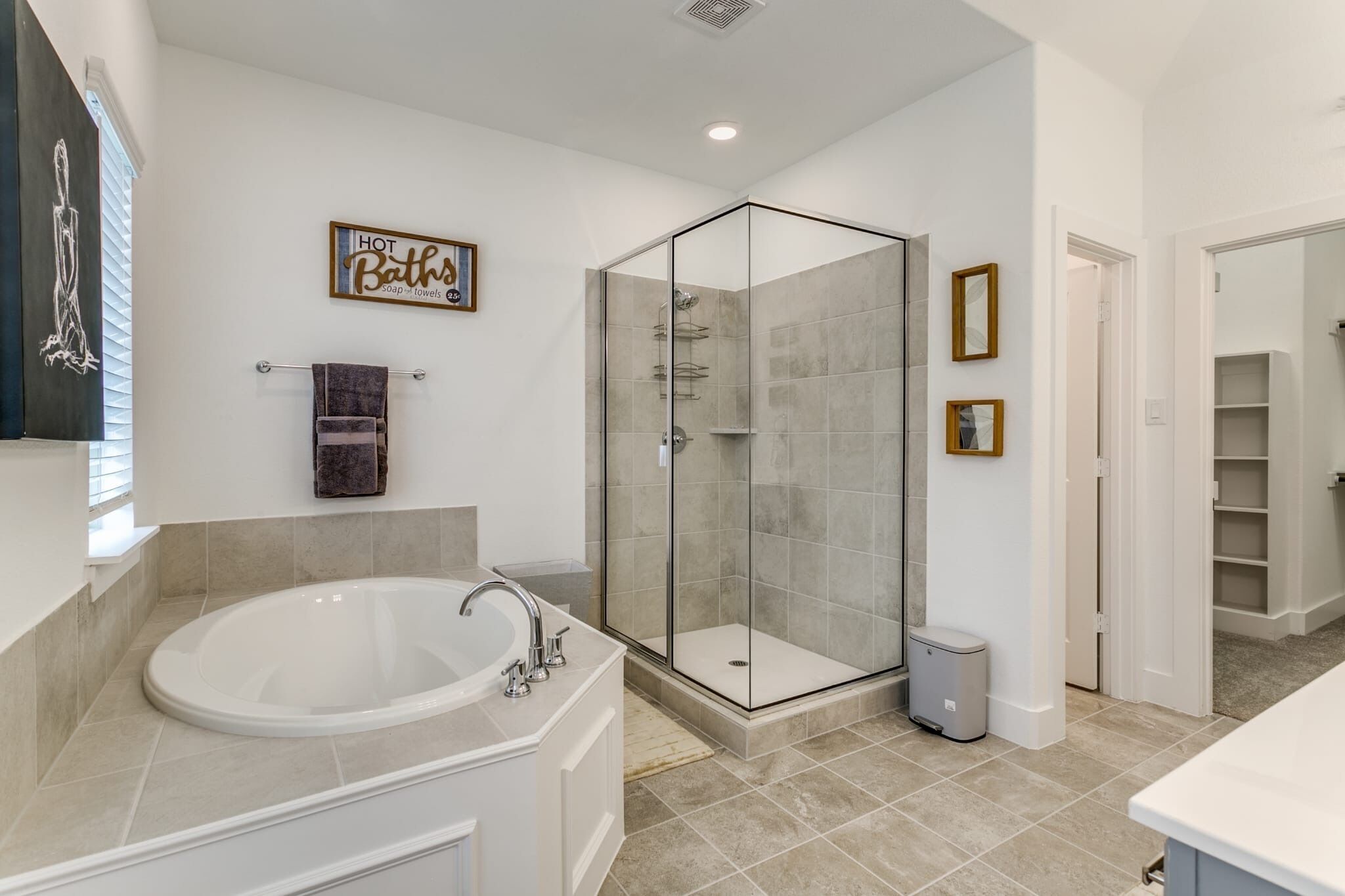 A modern bathroom with a freestanding bathtub, a glass-enclosed shower, and a towel rack.
