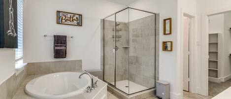 A modern bathroom with a freestanding bathtub, a glass-enclosed shower, and a towel rack.