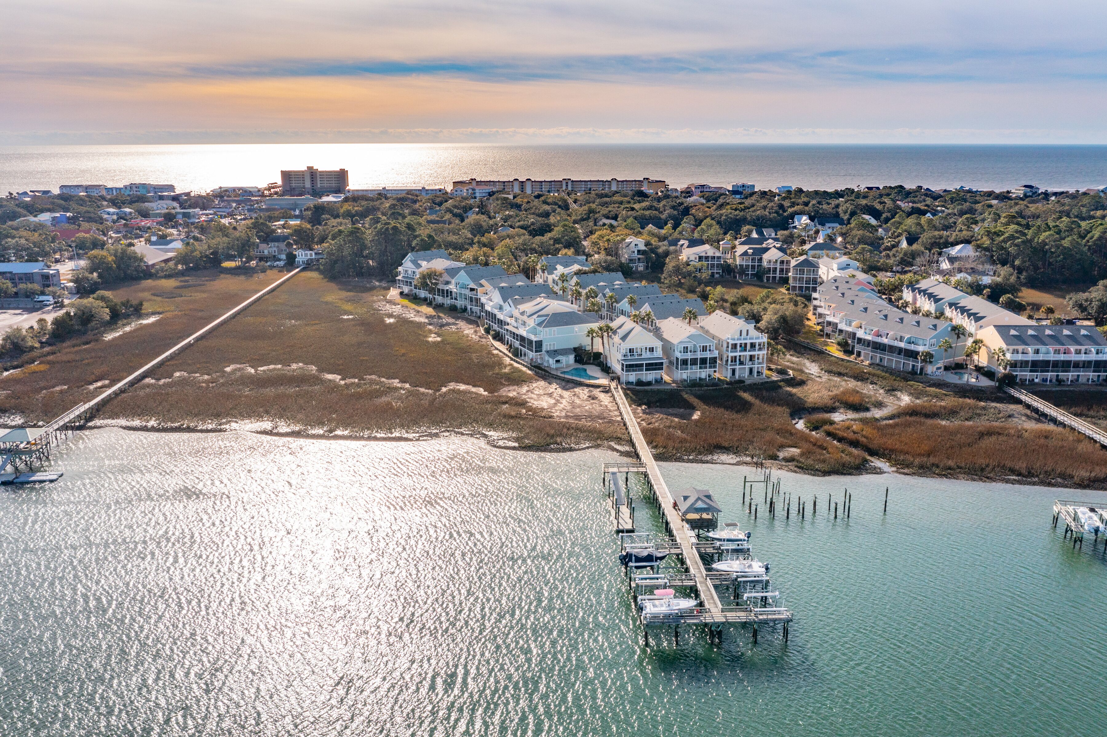 A coastal resort with multiple buildings, a pier, and boats docked.