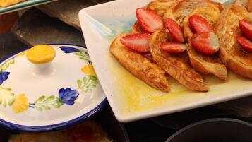 A breakfast plate with waffles, scrambled eggs, and toast with strawberries.