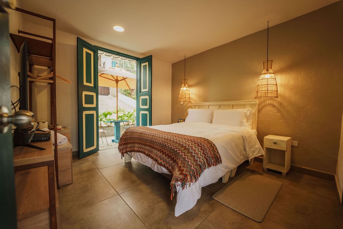 Ein Schlafzimmer mit Bett, Nachttischen, Schreibtisch und Stuhl.