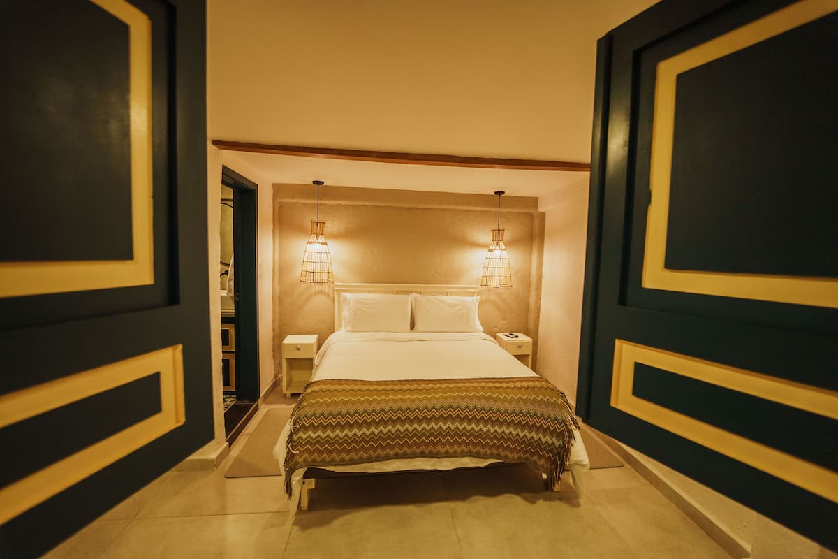 Ein Hotelzimmer mit einem Bett, Nachttischen und zwei Wandlampen.