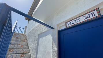 Un bâtiment avec une porte bleue et une enseigne sur laquelle on peut lire « VISTA MAR ».