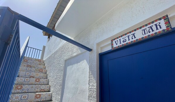 A building with a blue door and a sign that reads "VISTA MAR".