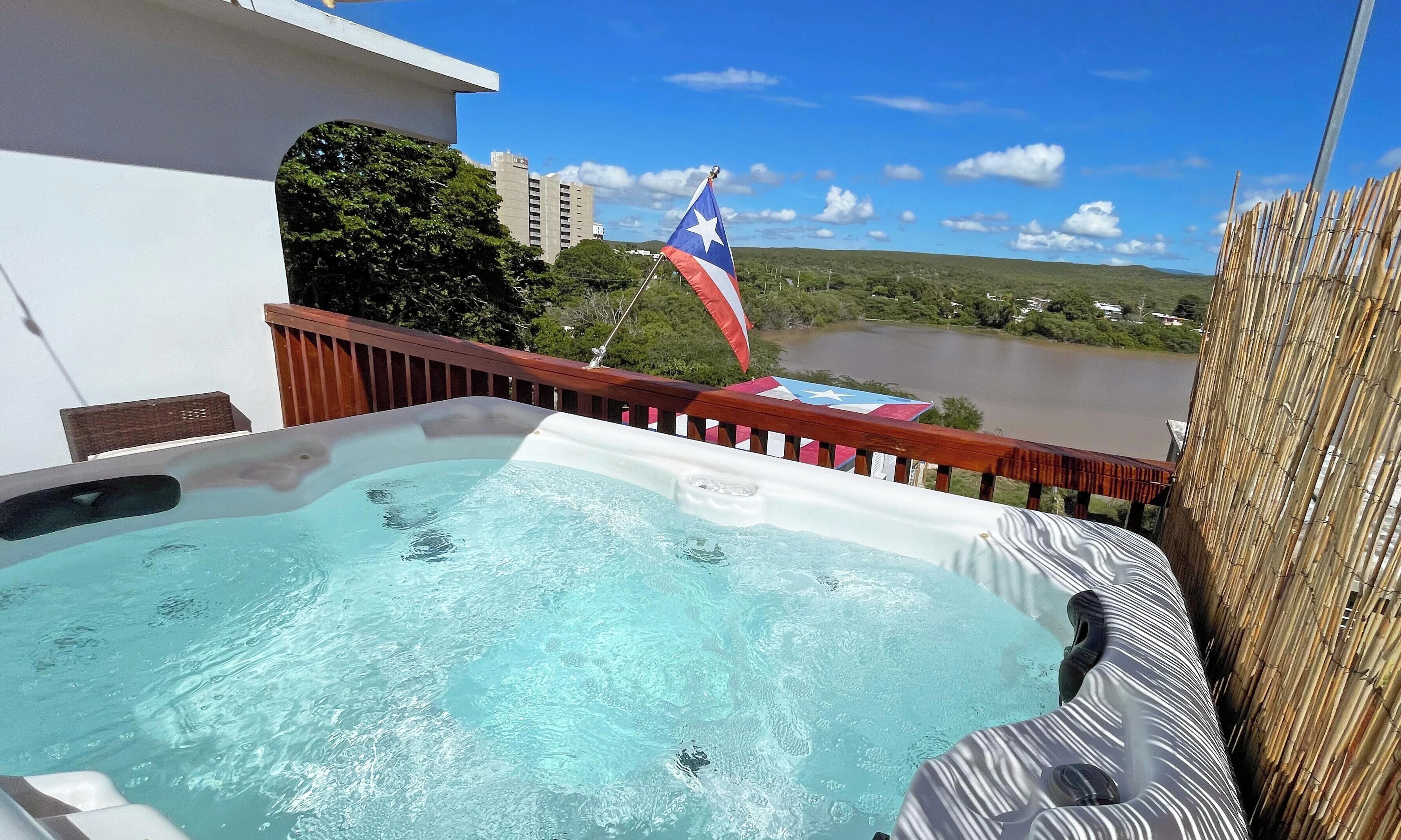 A hot tub with a view of a lake and a flag.