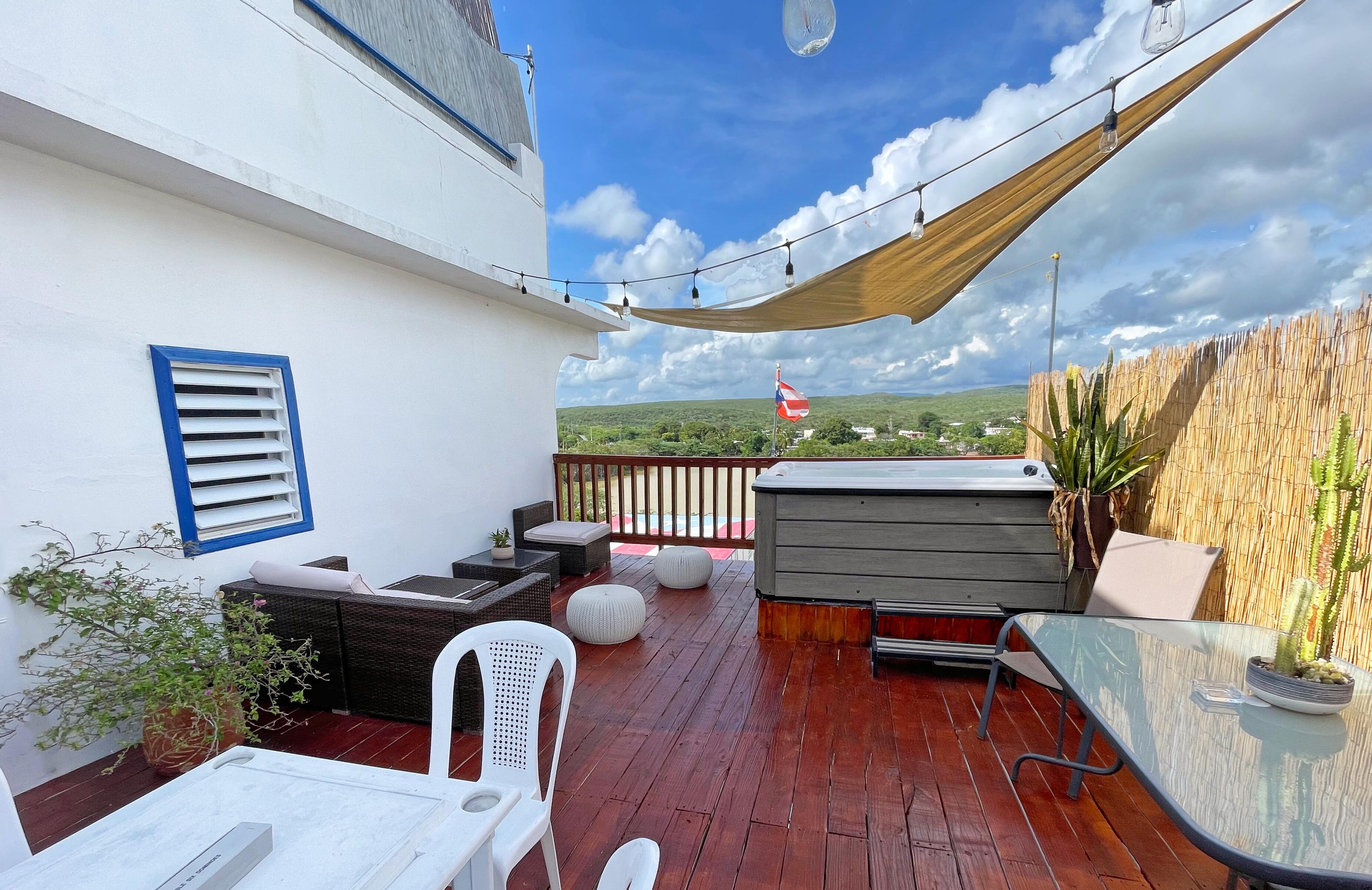A wooden deck with outdoor furniture, a hot tub, and a view of the countryside.