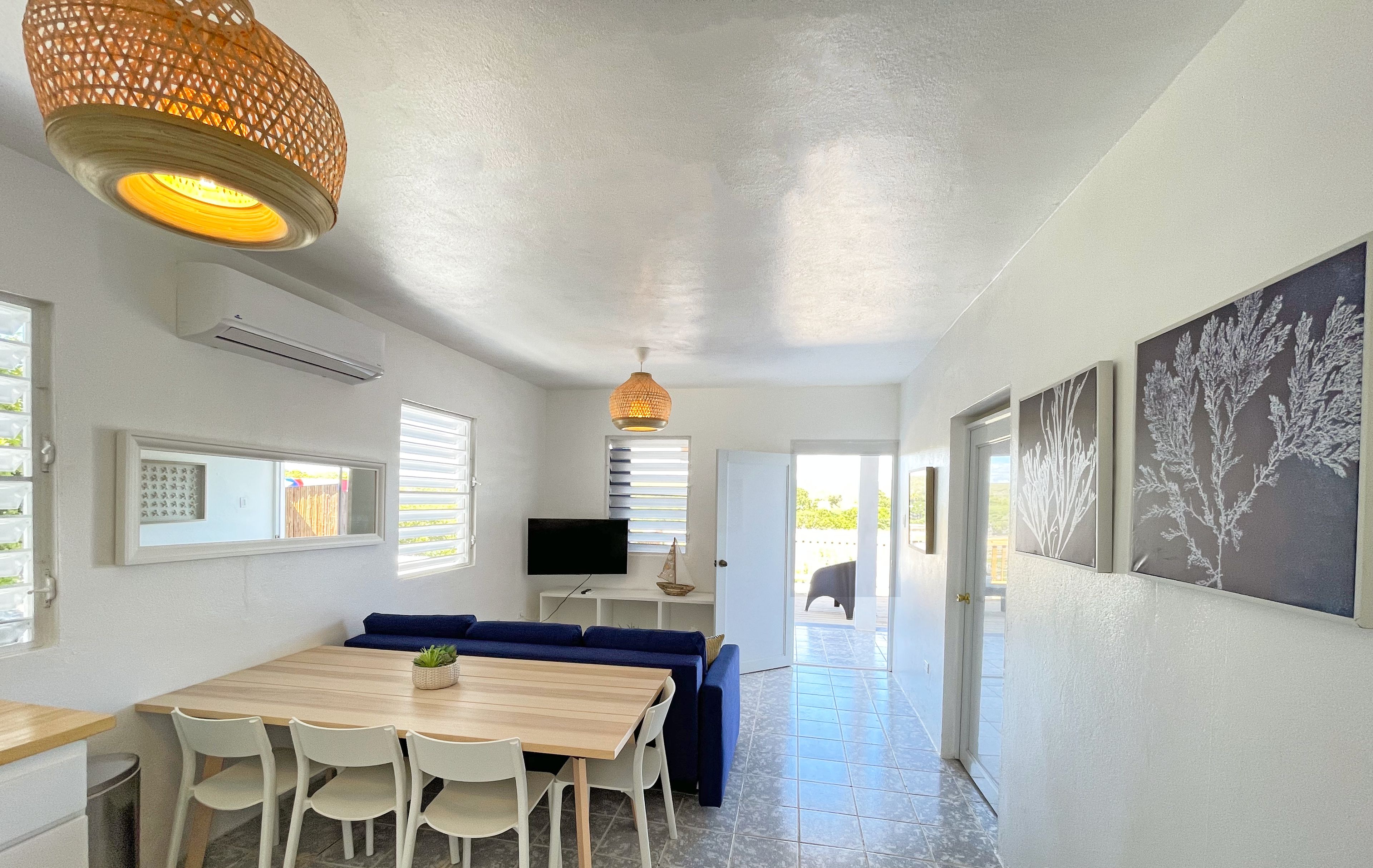 A modern interior with a dining area, a TV, and artwork on the walls.