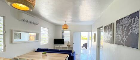 A modern interior with a dining area, a TV, and artwork on the walls.