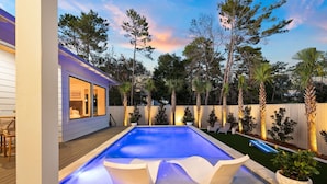 A swimming pool with a wooden deck, surrounded by a wooden fence and palm trees. - Private Heated Pool, Single-Level Home, Golf Cart (Inlet Beach)