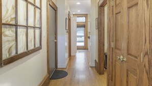 A hallway with wooden doors, a doormat, and a view to another room. - Northern Michigan gem in a beautiful beach town. (Frankfort)