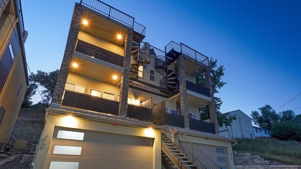 Un edificio residenziale a più piani con garage, scale e balconi.