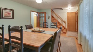 A dining area with a wooden table and chairs, a staircase, and a door leading to another room. - Large Home w/ Deck & Grill ~ 9 Mi to Virginia Tech (Christiansburg)