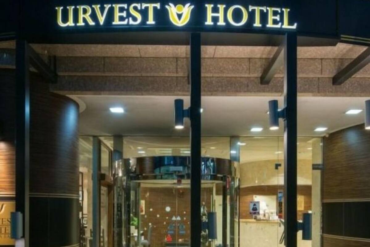 The entrance to the URVEST HOTEL with a glass door and a visible reception area inside.