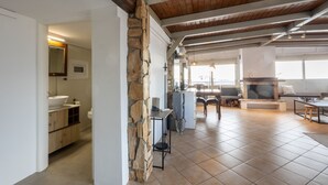 Un salón amplio con una pared de acento de piedra, una chimenea y un comedor.