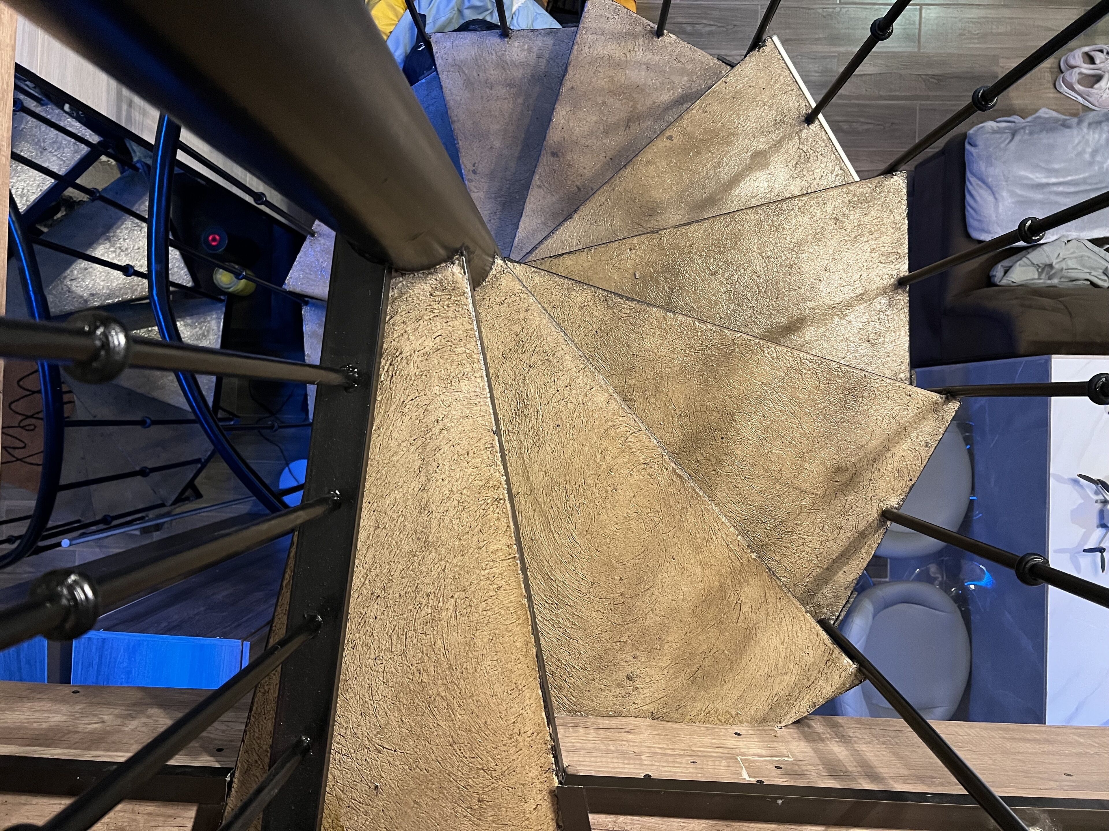 A spiral staircase with a wooden finish and metal railings.