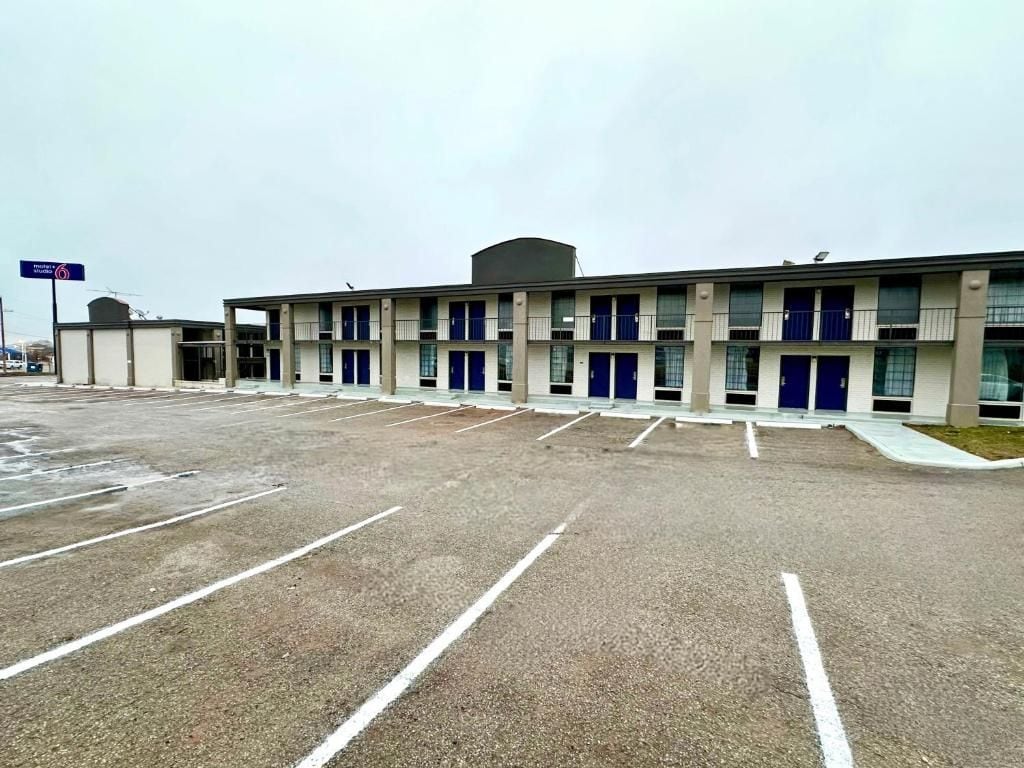 Un hôtel à plusieurs étages avec un parking situé à l’avant.