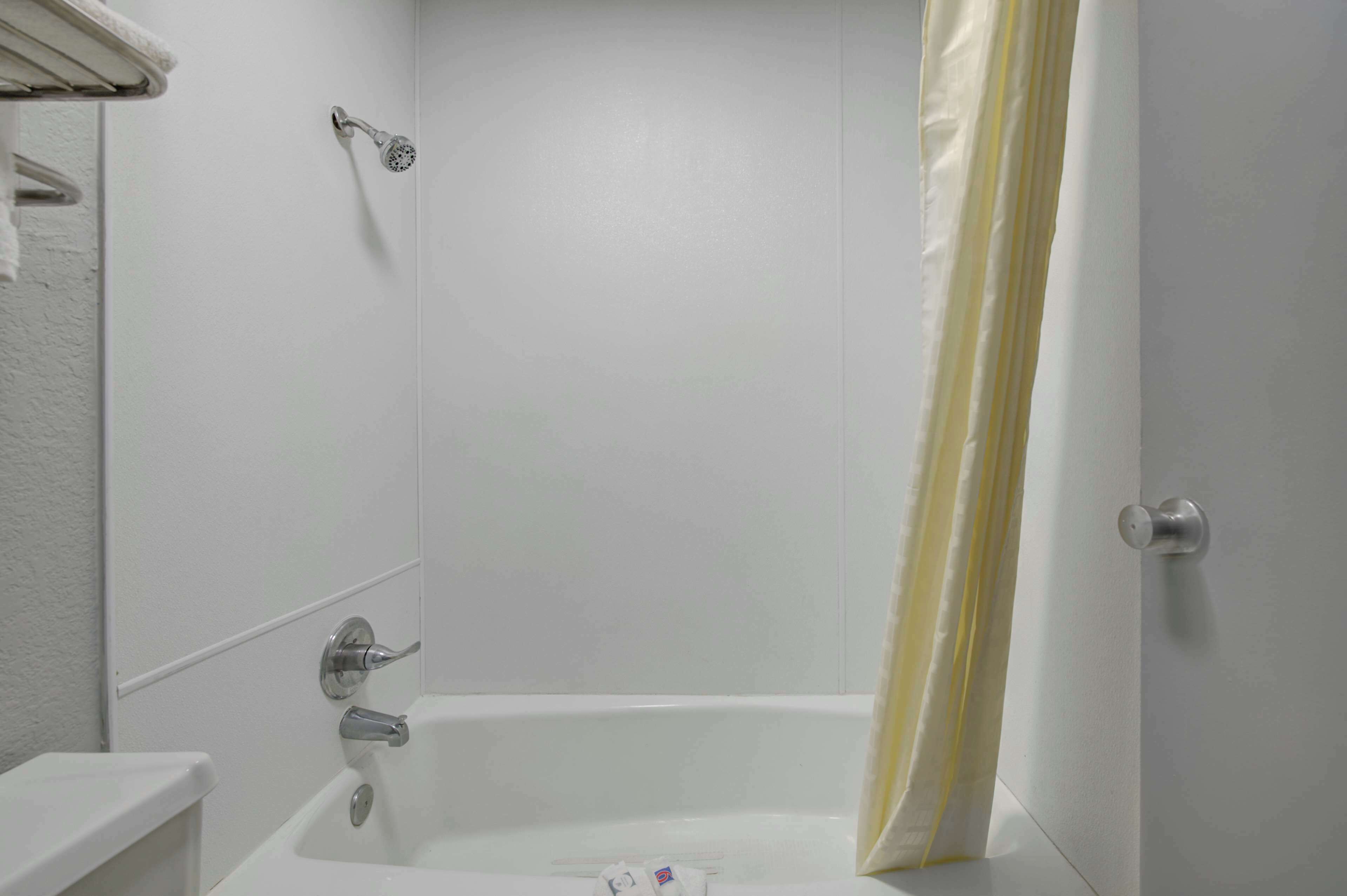 A bathroom with a bathtub, shower, and toilet.