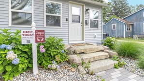 A residential property with a front door, a mailbox, and a sign indicating available rentals.
