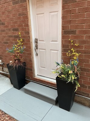A white door with a keyhole and a doormat.