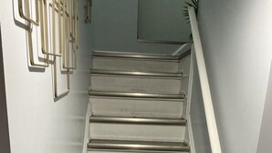 A staircase with wooden steps and white handrails, leading to a landing with a light switch and a small window. - Modern Cozy 2 BR Private Suite,5 Min drive -Creditview & Sandalwood Sports field (Brampton)