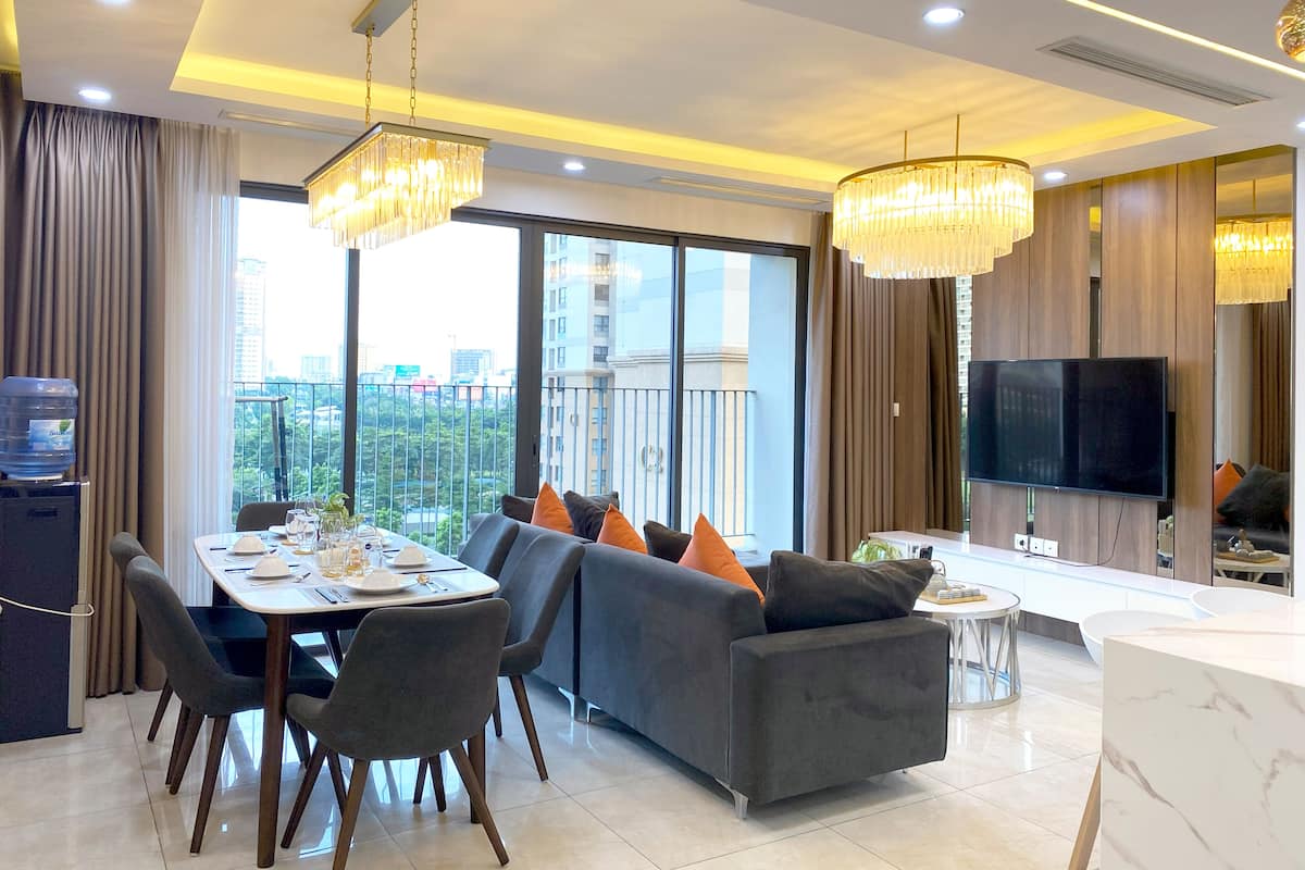 A modern living room with a dining area, large windows, and a balcony.