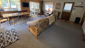 Ein gemütliches Blockhaus-Interieur mit einem Holzespeisetisch, Stühlen, einer Couch und einem Kamin.