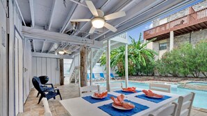 An outdoor dining area with a pool, chairs, and a ceiling fan. - Private Home w/Private pool1/2 block from Beach! Stylish Interior! Dog friendly! (South Padre Island)