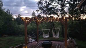 Eine Terrasse im Freien mit einer Holzlustdecke, Hängematten und Laternen.