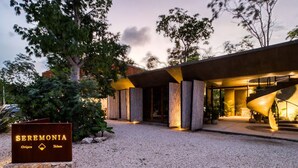 Een modern gebouw met een bord waarop “SEREMONIA Origen Tulum” staat.