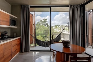 Eine moderne Küche mit einer großen Schiebeglasdoor, die zu einem Balkon mit einer Hängematte führt.