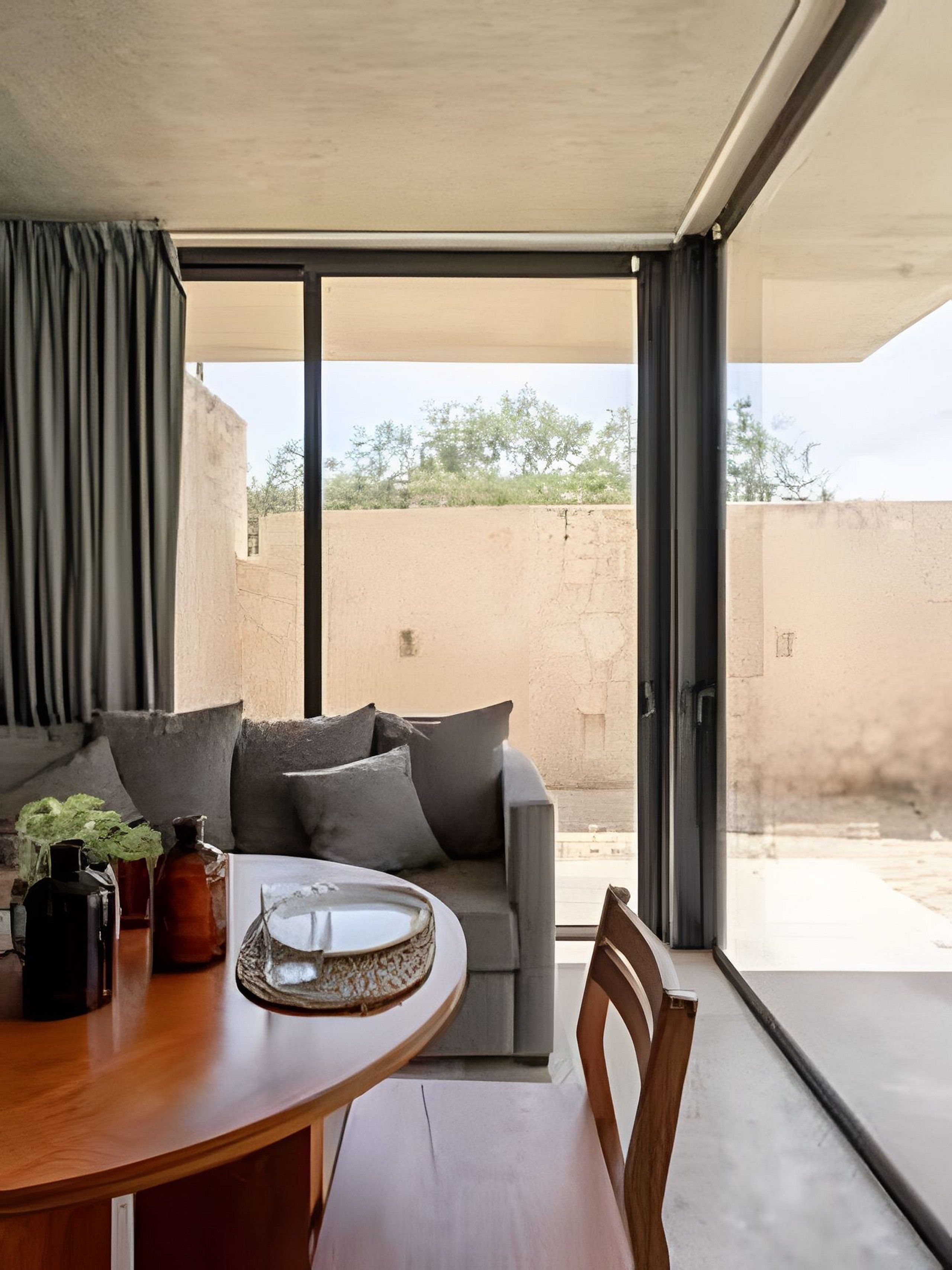 Un interior moderno con una mesa de comedor, un sofá y vistas al exterior.