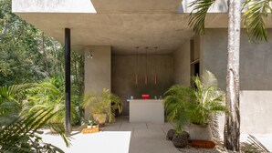 Een moderne, open receptiezone met een betonnen structuur, plantenbakken en een minimalistisch ontwerp.