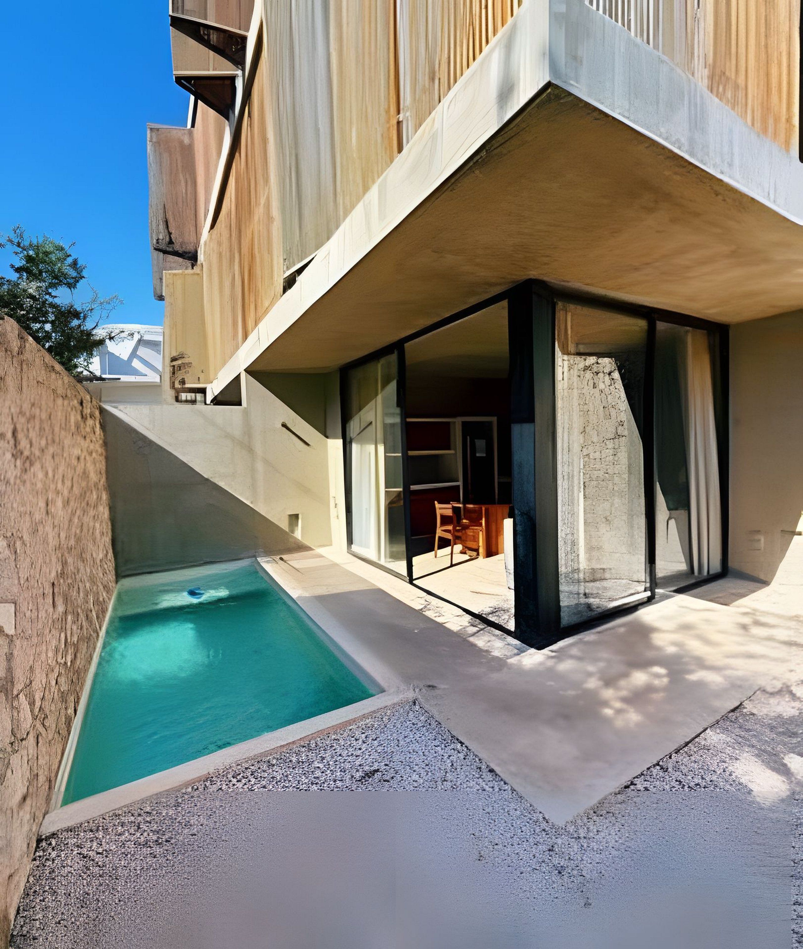 Um edifício moderno com piscina, área de estar externa e vista para as montanhas.