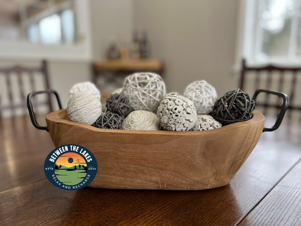 A wooden bowl filled with decorative balls on a wooden table. - Charming home in the heart of Northern Michigan's destinations and activities. (Cheboygan)