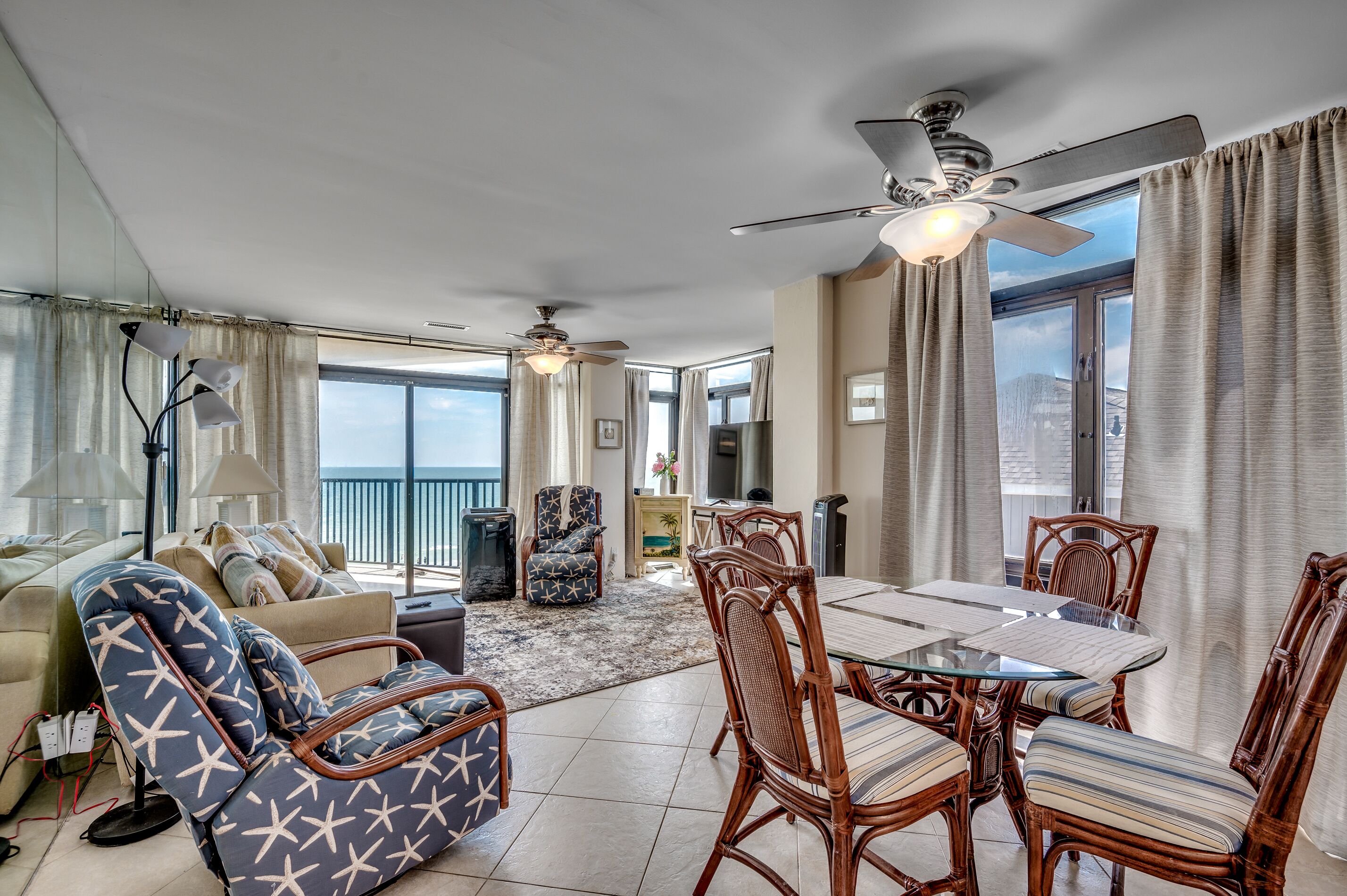 A spacious living area with a balcony, a dining table with chairs, and a seating area with a sofa and chairs.