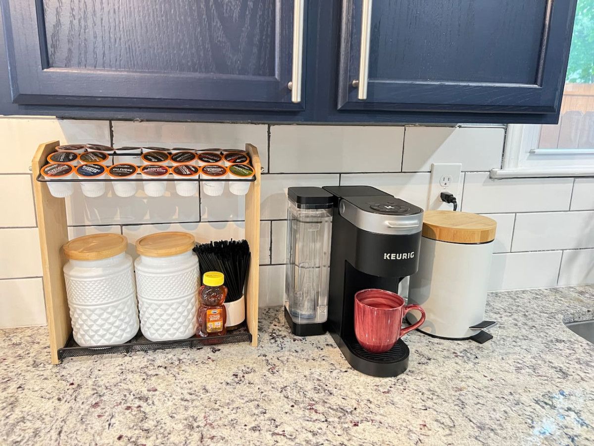 A kitchen counter with a coffee maker, a mug, spice jars, and a knife block.