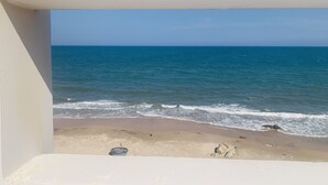 A beach view from a balcony with a clear sky and calm sea. - BO BIEN VANG HOTEL (Tan Thanh)
