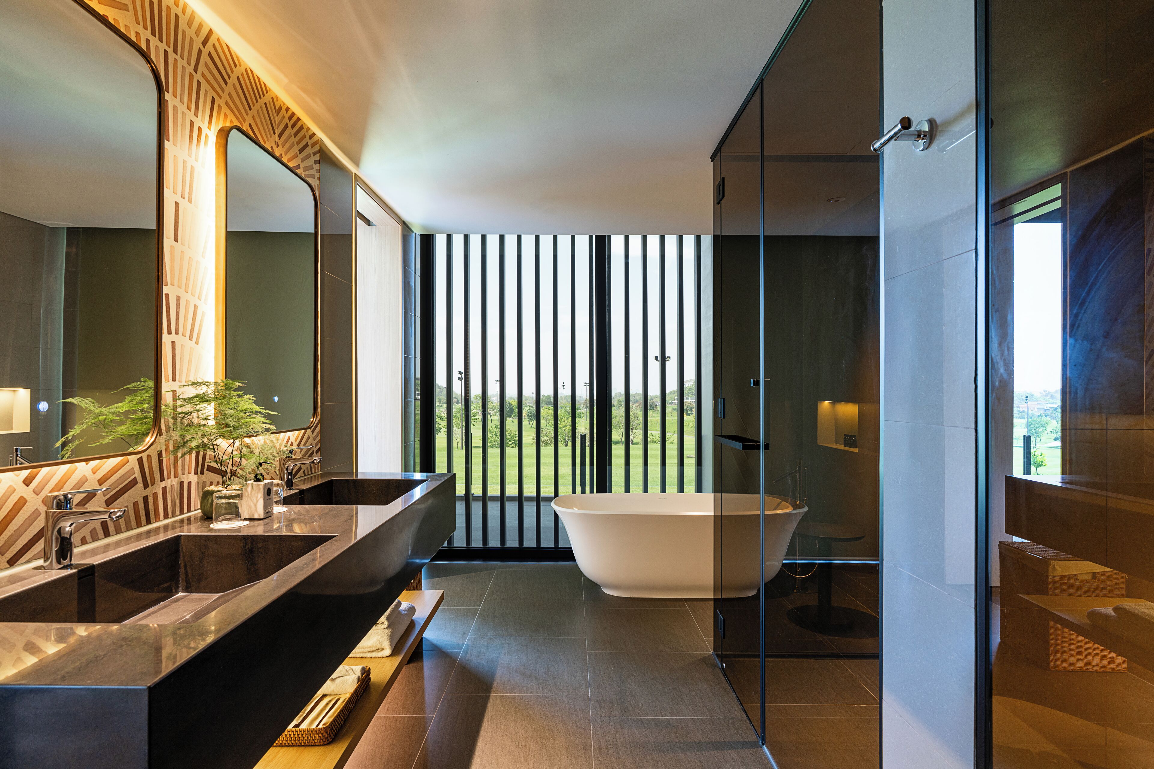 Une salle de bain moderne dotée d’une grande baignoire, d’un meuble-lavabo à deux vasques et d’un grand miroir.