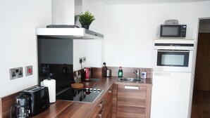 A modern kitchen with a built-in stove, microwave, and sink. - Apartment - Sleeps 4 - Pet friendly - WiFi (Sheffield)