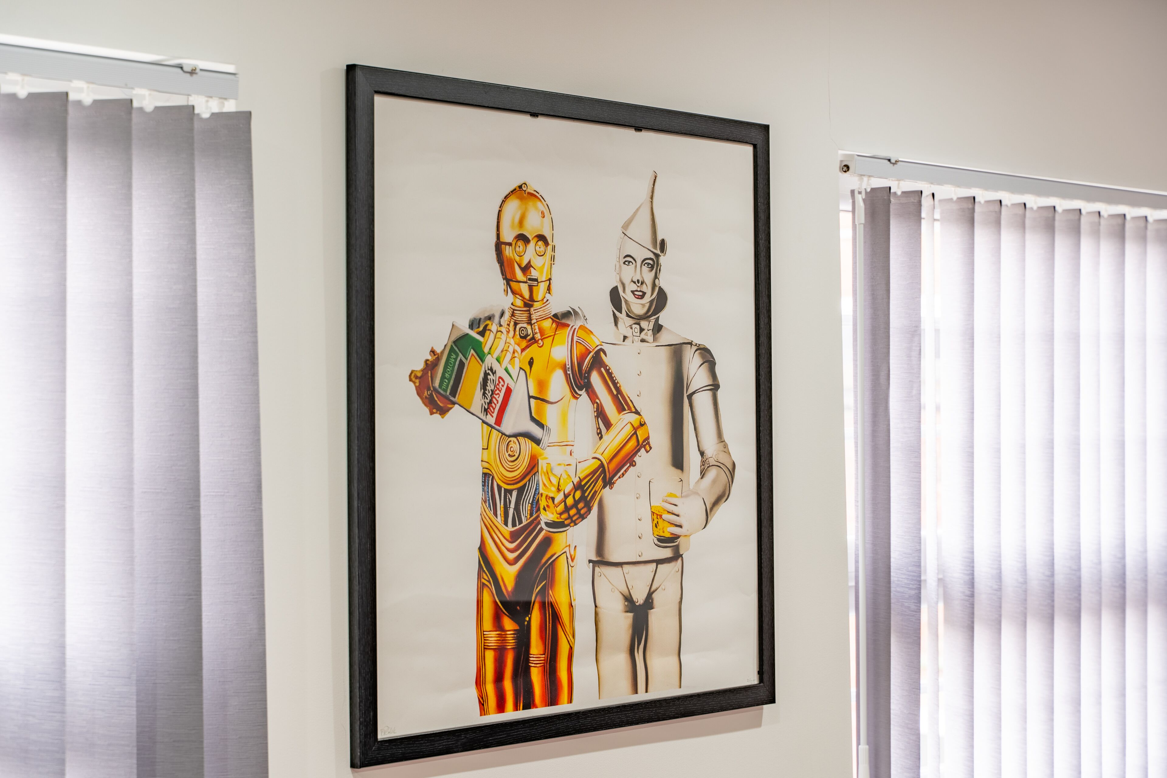 A framed artwork of two characters on a wall.