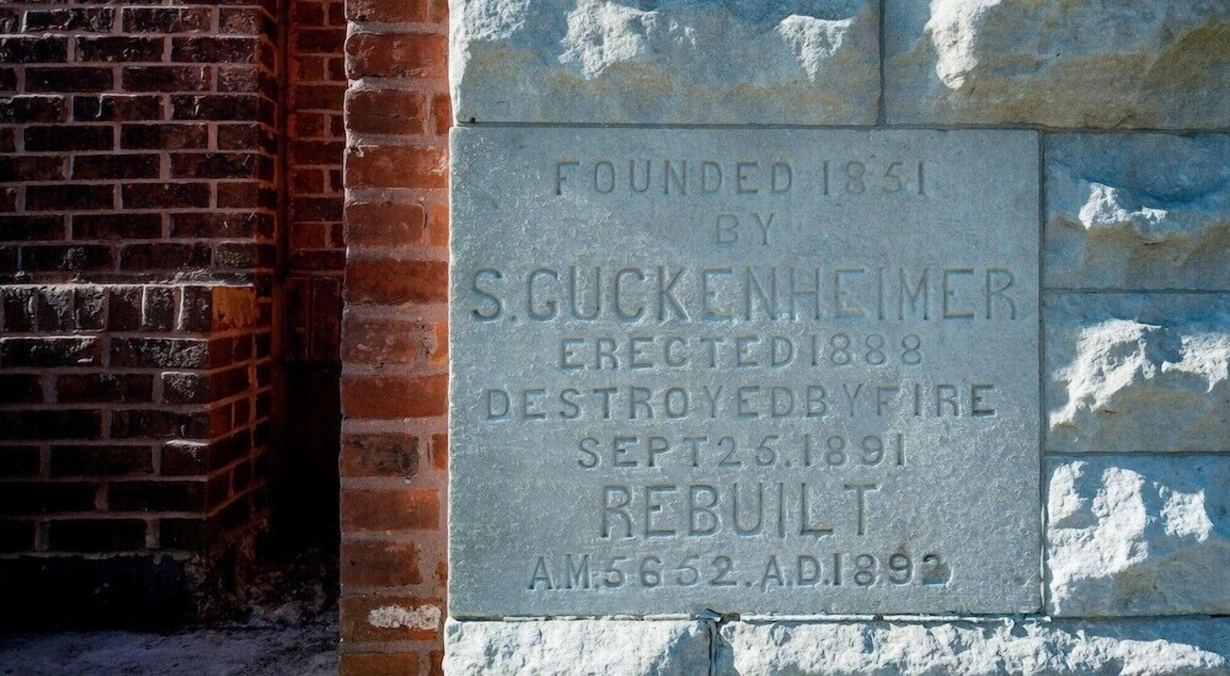 Una placa histórica fijada en una pared de ladrillo.