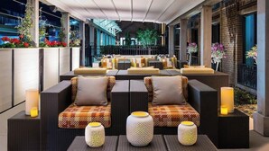 A rooftop lounge area with outdoor seating, including sofas and chairs, and decorative lanterns. - 1-Bedroom Suite at a 4⭐️ Hotel (Savannah)