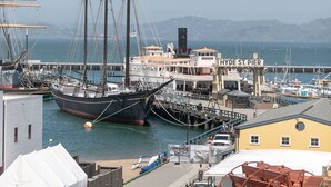 Um porto com um grande navio à vela atracado, um cais e um edifício com a inscrição 'HYDE ST. PIER'.