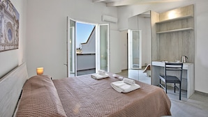 A bedroom with a bed, a desk, and a chair. There is a window and an air conditioning unit. - Villa Cristal Pool and Padel, Galatina, Italy (Galatina)