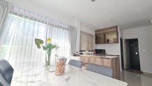 A modern kitchen with a marble countertop, a built-in oven, and a sink. - Castello Di Mare (Cha-am)