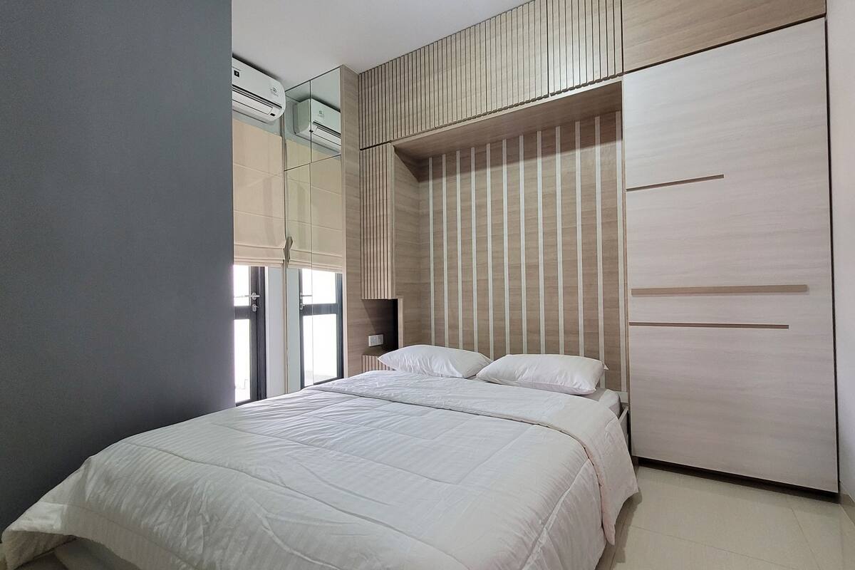 Ein Schlafzimmer mit Bett, Kleiderschrank und Spiegel.