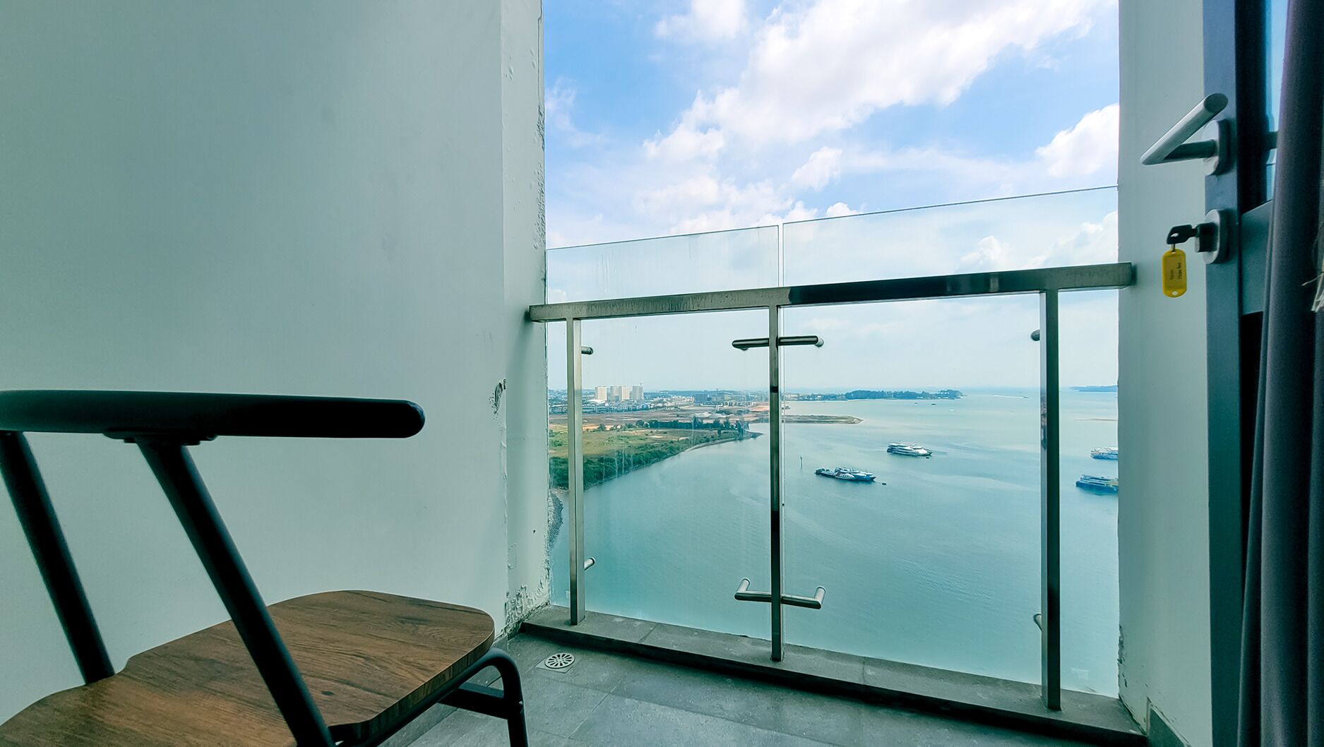 A balcony with a view of a body of water and distant buildings.